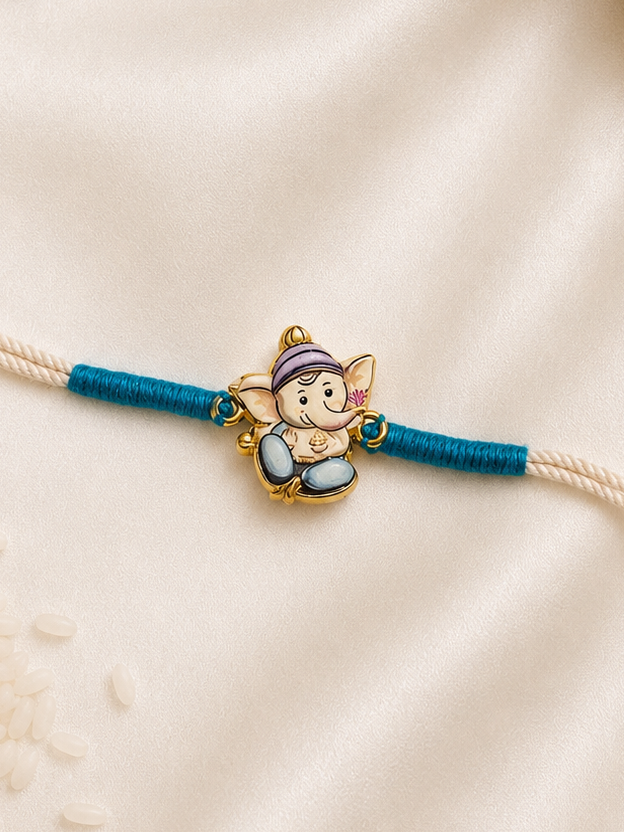 Kids Ganesha Rakhi with colorful enamel Lord Ganesha charm on a white thread with teal accents, displayed on a silk background.