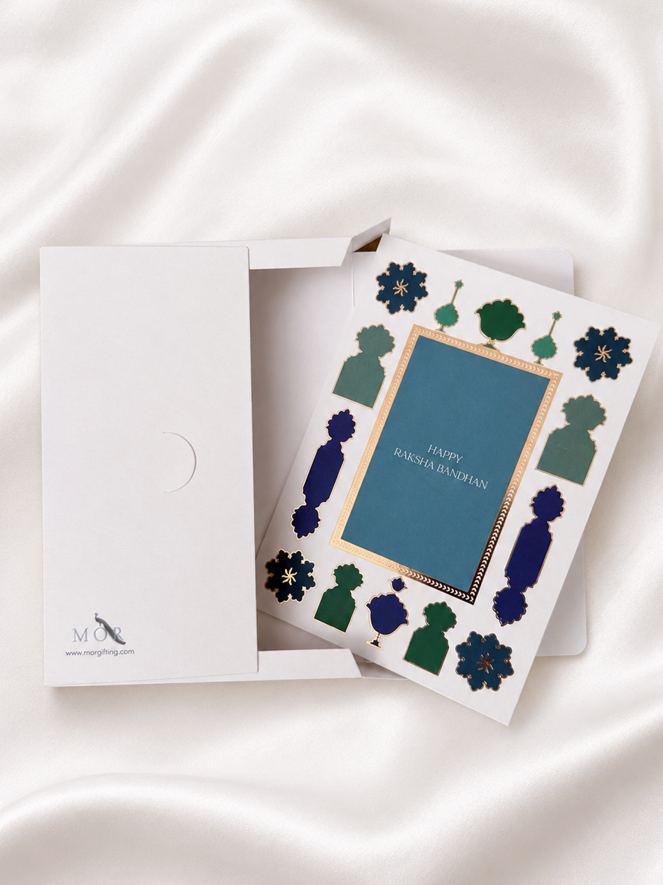 Premium Raksha Bandhan greeting card with blue and green foil accents and coordinating white gift box, designed to hold a greeting card and rakhi for elegant gifting.