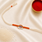 Kids Rainbow Rakhi with colorful rainbow and cloud enamel charm on a white thread with orange accents on a silk background.