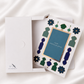 Premium Raksha Bandhan greeting card with blue and green foil accents and coordinating white gift box, designed to hold a greeting card and rakhi for elegant gifting.